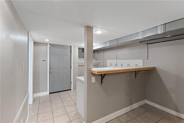 interior space featuring light tile patterned floors and baseboards