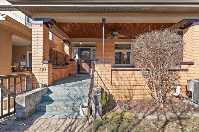 exterior space with brick siding, cooling unit, a porch, and a ceiling fan