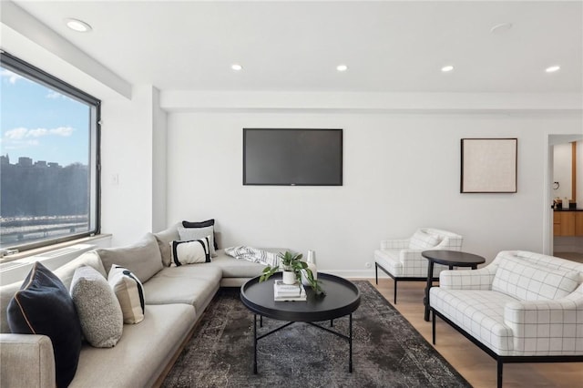 living area with baseboards, wood finished floors, and recessed lighting