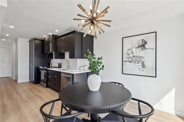 dining room with recessed lighting, light wood-style floors, baseboards, and a notable chandelier