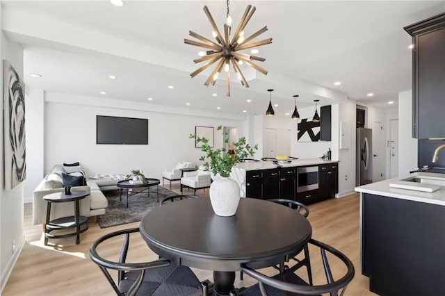 dining space featuring baseboards, an inviting chandelier, light wood finished floors, and recessed lighting