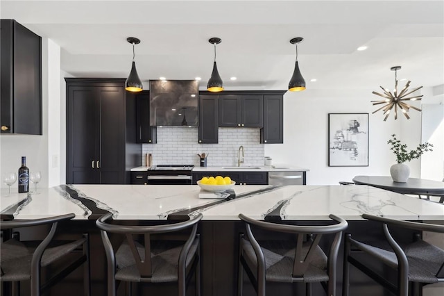 kitchen with stainless steel appliances, ventilation hood, a sink, decorative backsplash, and hanging light fixtures