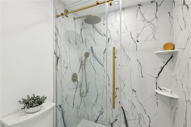 bathroom featuring a marble finish shower and toilet