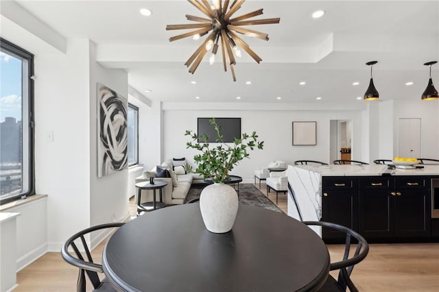 dining area with recessed lighting, light wood-type flooring, baseboards, and an inviting chandelier