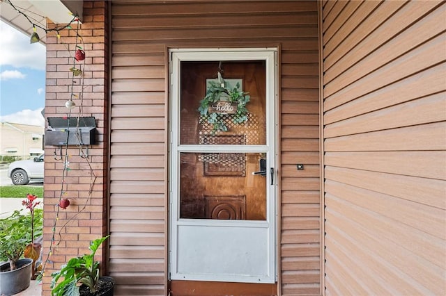 view of exterior entry with brick siding