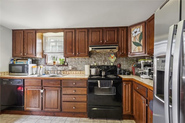 kitchen with decorative backsplash, black appliances, light countertops, and under cabinet range hood