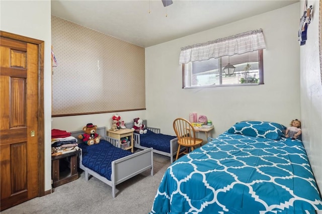 bedroom with wallpapered walls, carpet, and a ceiling fan