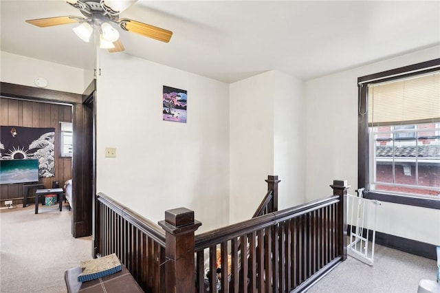 corridor with an upstairs landing and carpet