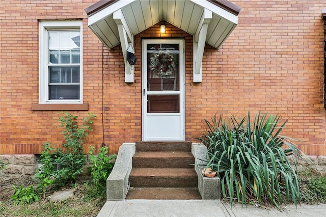 entrance to property featuring brick siding