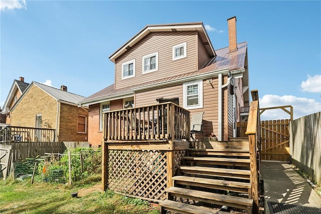 rear view of house with stairs, a fenced backyard, a chimney, and a wooden deck