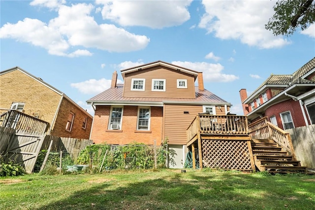 back of property featuring a wooden deck, brick siding, a yard, and fence