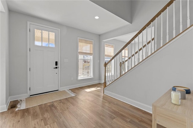 entrance foyer with stairway, recessed lighting, baseboards, and wood finished floors