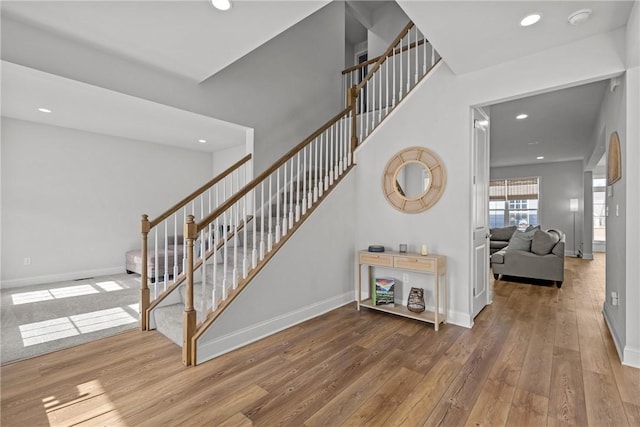 stairs with recessed lighting, baseboards, and wood-type flooring