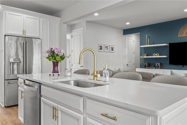 kitchen featuring recessed lighting, a sink, white cabinets, appliances with stainless steel finishes, and light wood-type flooring