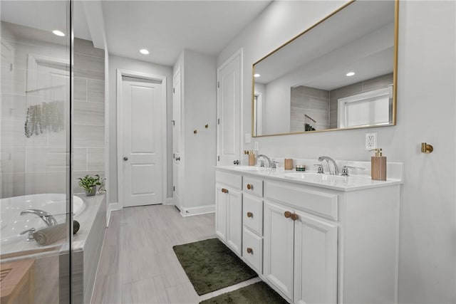 bathroom with a sink, a garden tub, double vanity, and a tile shower