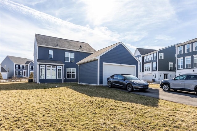 exterior space with an outdoor structure, a garage, a residential view, and a front yard