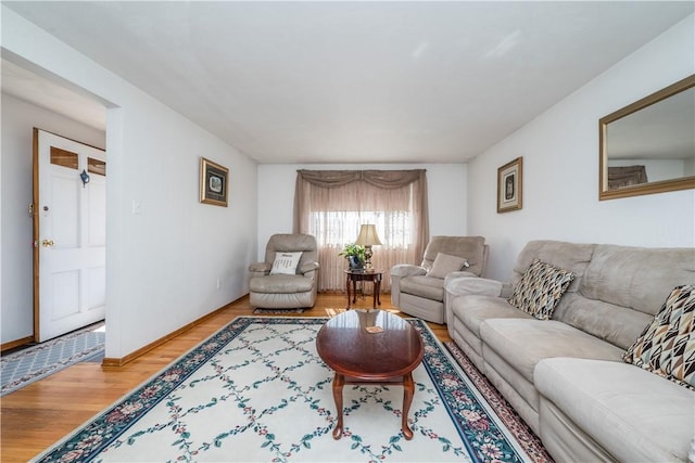 living area featuring baseboards and light wood-type flooring