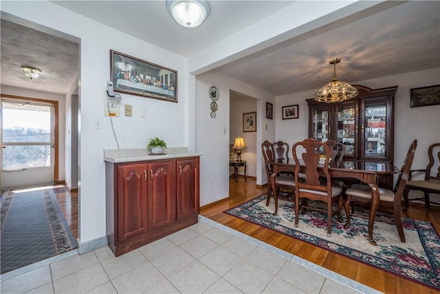 dining area with light tile patterned flooring and baseboards