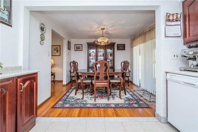 dining area with light wood-style flooring and a chandelier