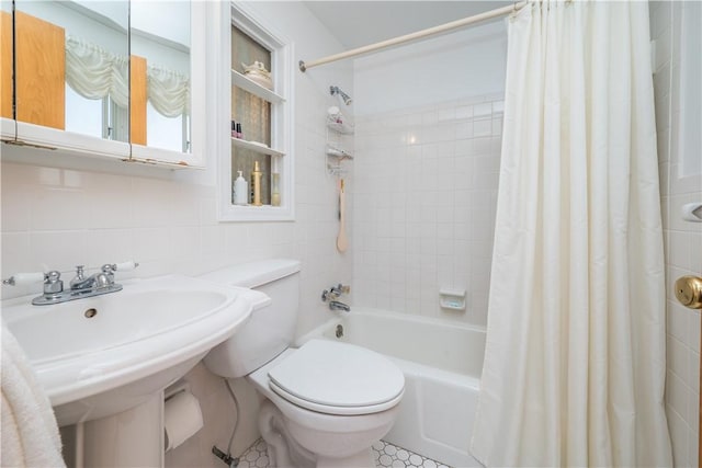 full bath with a sink, decorative backsplash, shower / bath combo with shower curtain, tile walls, and toilet