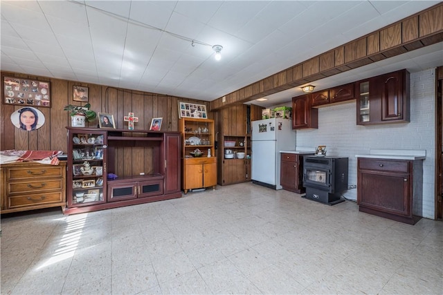 interior space featuring light floors, wood walls, and a wood stove