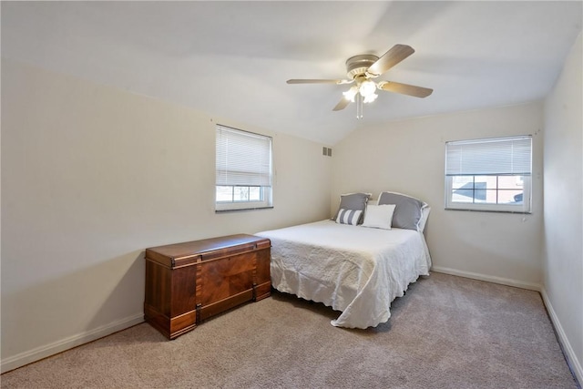 bedroom featuring vaulted ceiling, multiple windows, visible vents, and baseboards