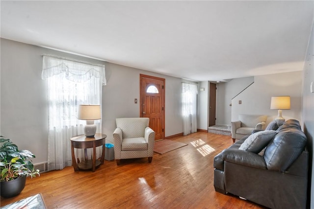 living room with wood finished floors, visible vents, and baseboards