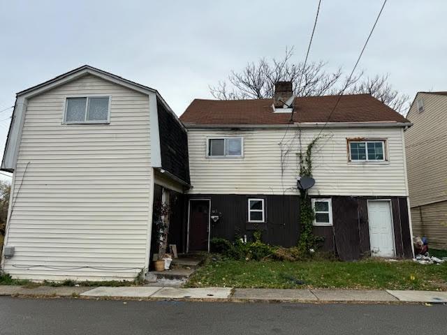 view of front of property featuring a gambrel roof and a chimney