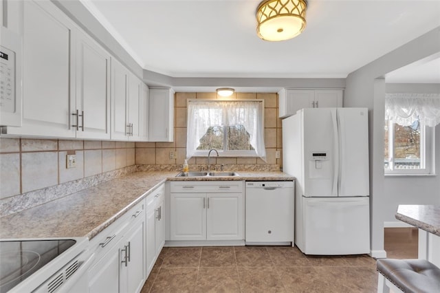 kitchen with a sink, decorative backsplash, white appliances, and white cabinetry