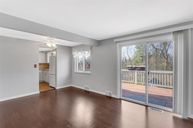 unfurnished living room with visible vents, baseboards, and wood finished floors