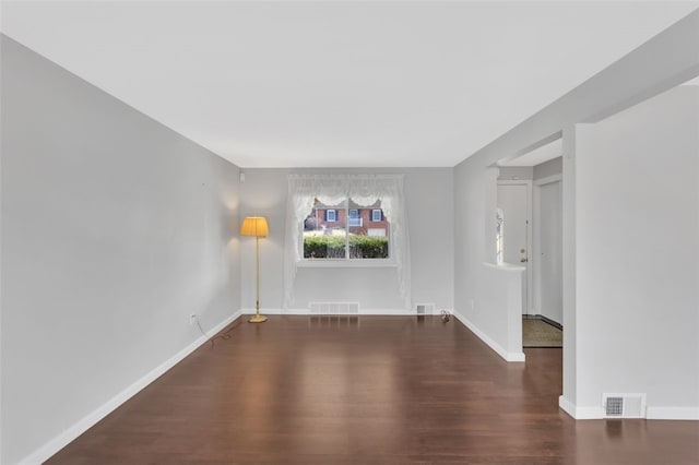 unfurnished room with visible vents, baseboards, and wood finished floors