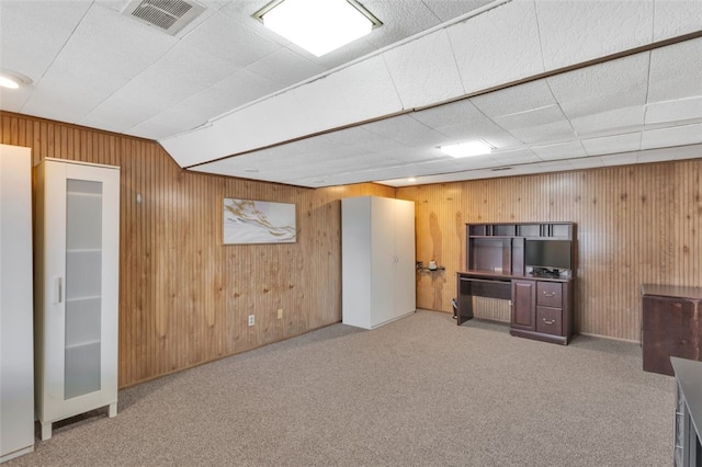 interior space with visible vents, wood walls, and carpet floors