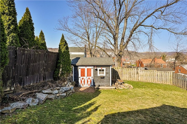 view of yard with an outbuilding, a storage shed, and a fenced backyard