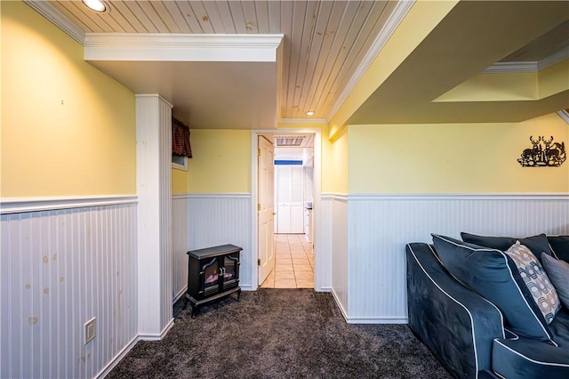 interior space with wooden ceiling, crown molding, a wainscoted wall, and carpet floors