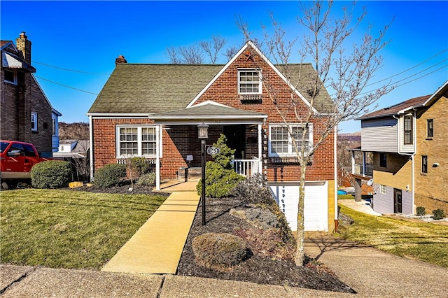 view of front of home with a garage, brick siding, roof with shingles, and a front yard