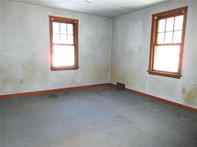 carpeted empty room featuring baseboards