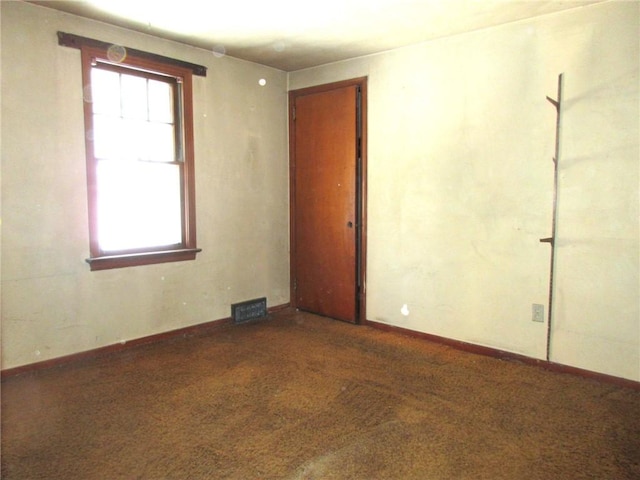 empty room featuring baseboards, carpet, visible vents, and a healthy amount of sunlight