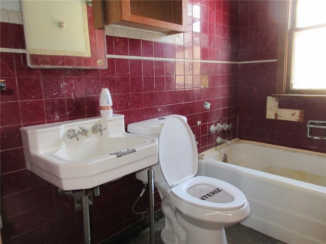 bathroom with toilet, tile walls, and a sink