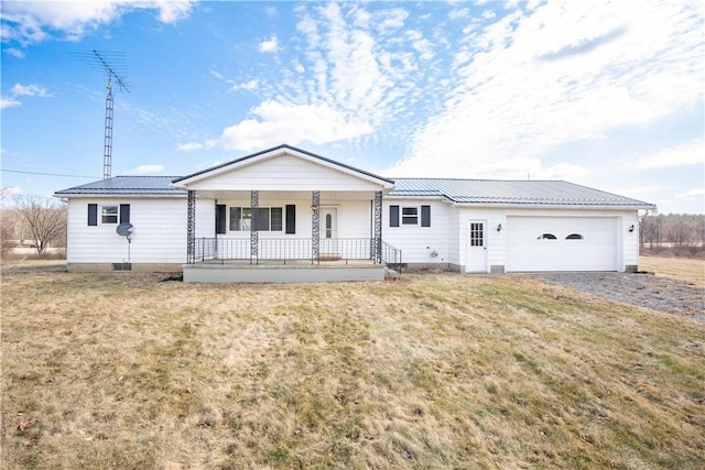 ranch-style home featuring metal roof, a garage, covered porch, and a front yard