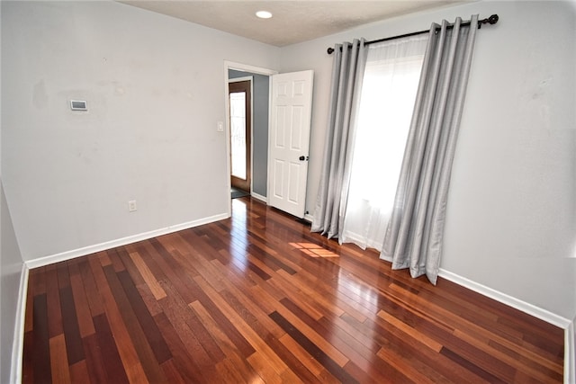 unfurnished room featuring baseboards and wood-type flooring