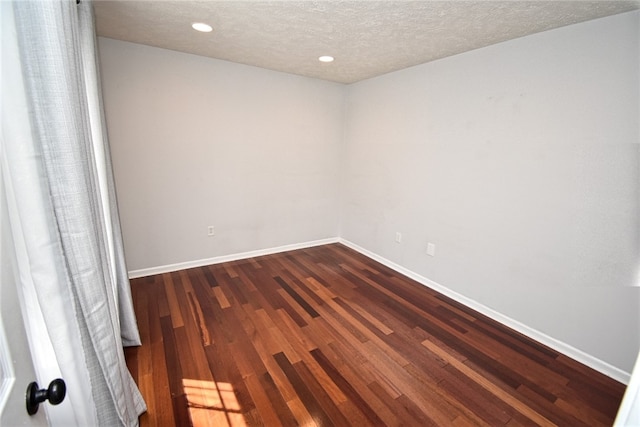 spare room with recessed lighting, baseboards, dark wood-style flooring, and a textured ceiling