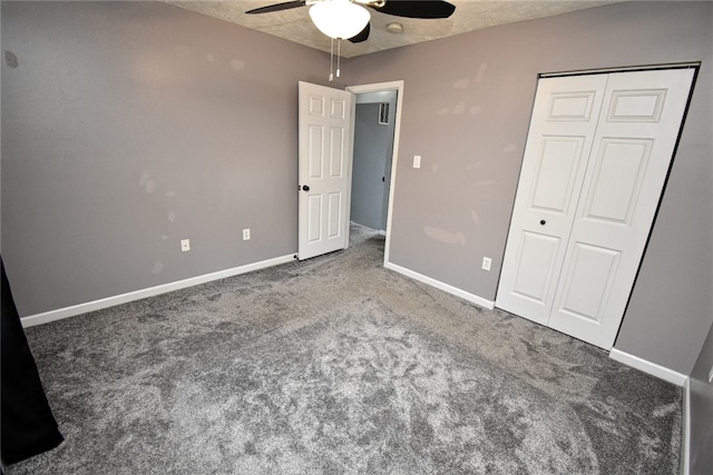 unfurnished bedroom with carpet, baseboards, ceiling fan, a closet, and a textured ceiling