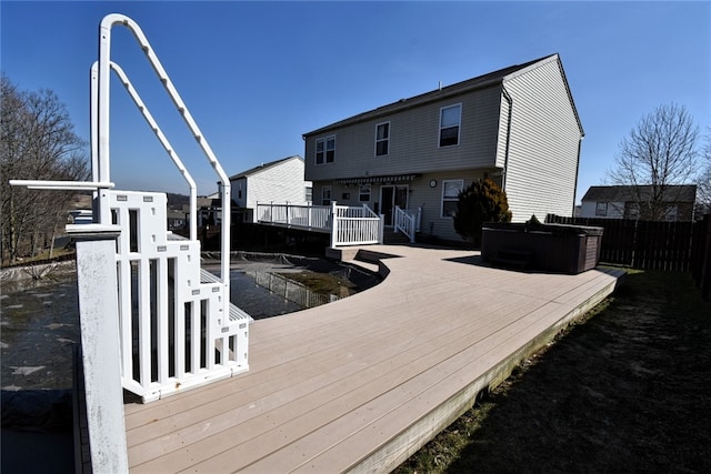 back of property featuring a deck and fence