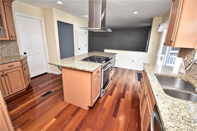 kitchen featuring dark wood-style flooring, island exhaust hood, stainless steel appliances, and a sink