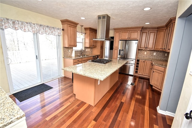 kitchen with dark wood-type flooring, a sink, a kitchen island, ventilation hood, and stainless steel appliances