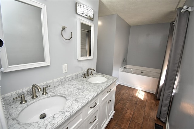 full bath with a bath, wood finished floors, visible vents, and a sink