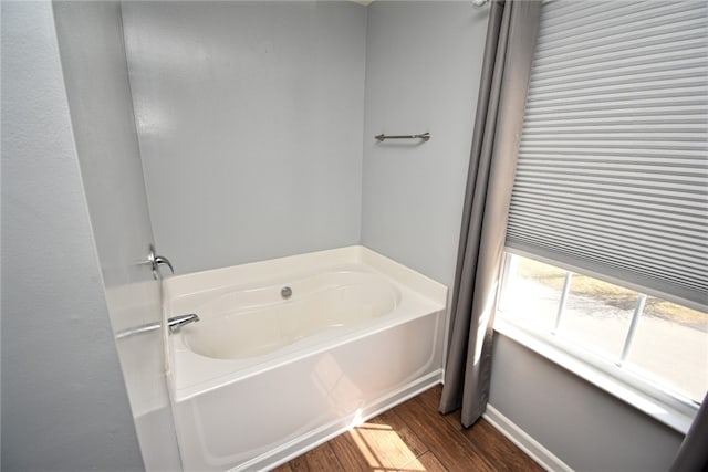 bathroom featuring a garden tub and wood finished floors