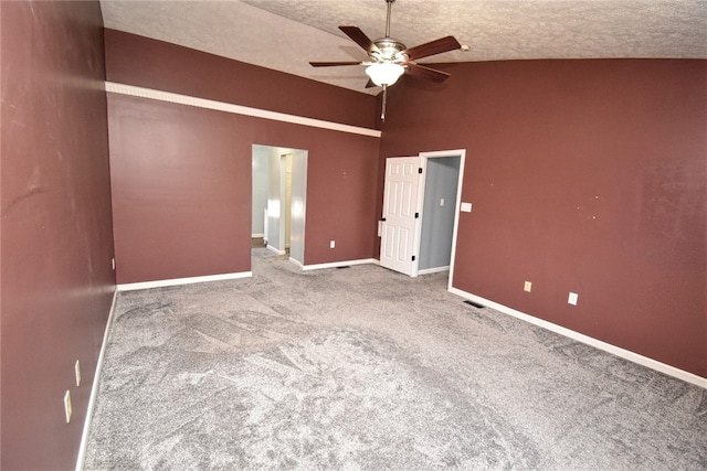 carpeted empty room featuring visible vents, a ceiling fan, a textured ceiling, baseboards, and vaulted ceiling