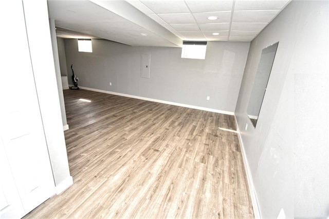 basement featuring recessed lighting, a paneled ceiling, baseboards, and wood finished floors