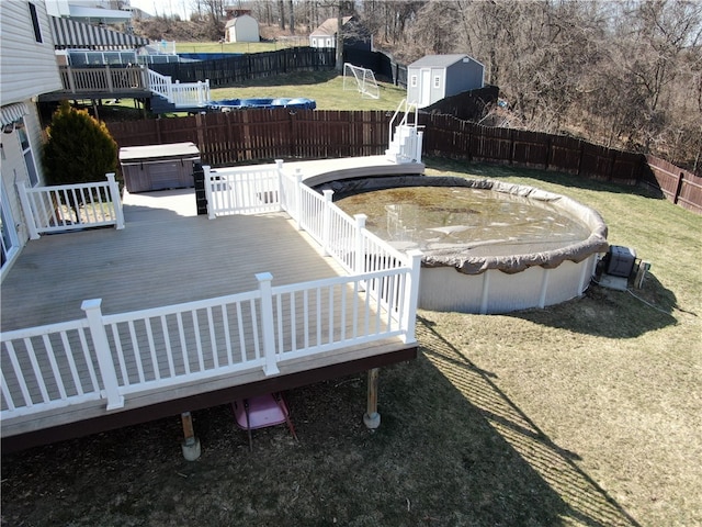 exterior space featuring a fenced backyard, a yard, a deck, and a hot tub